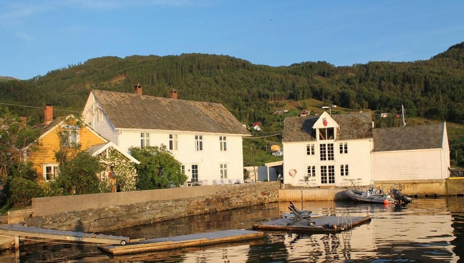 Traditional buildings by the fjord in Herand, Hardanger. Kramsjø is a picturesque guesthouse with stunning views.