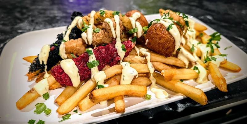Loaded fries med kjøtt, saus og topping servert hos The Grill Pit.