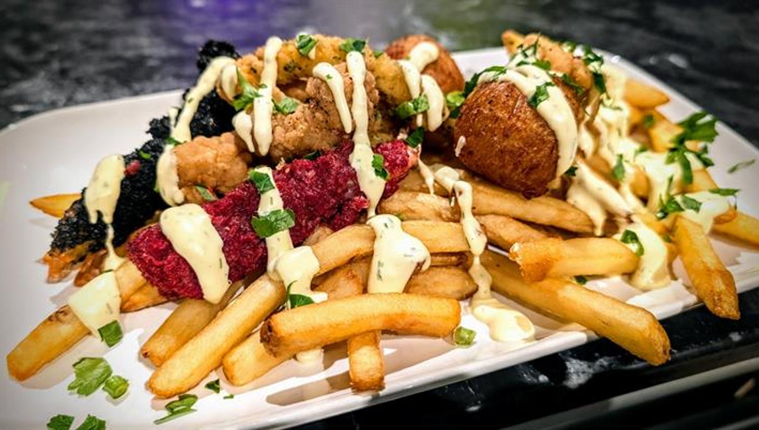 Loaded fries med kjøtt, saus og topping servert hos The Grill Pit.