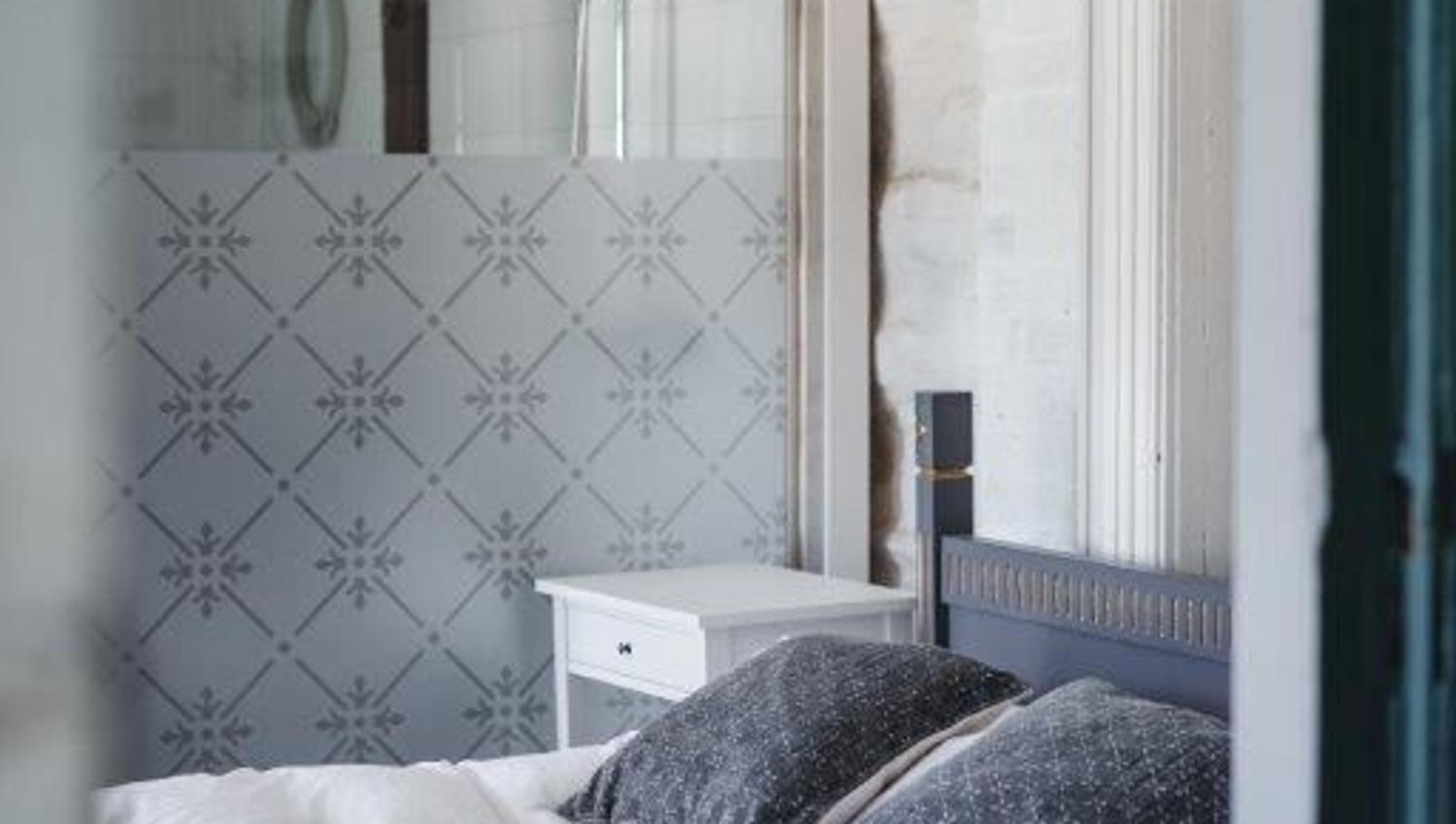 A traditionally furnished bedroom at Skrivergaarden with a double bed, classic details and a private bathroom.