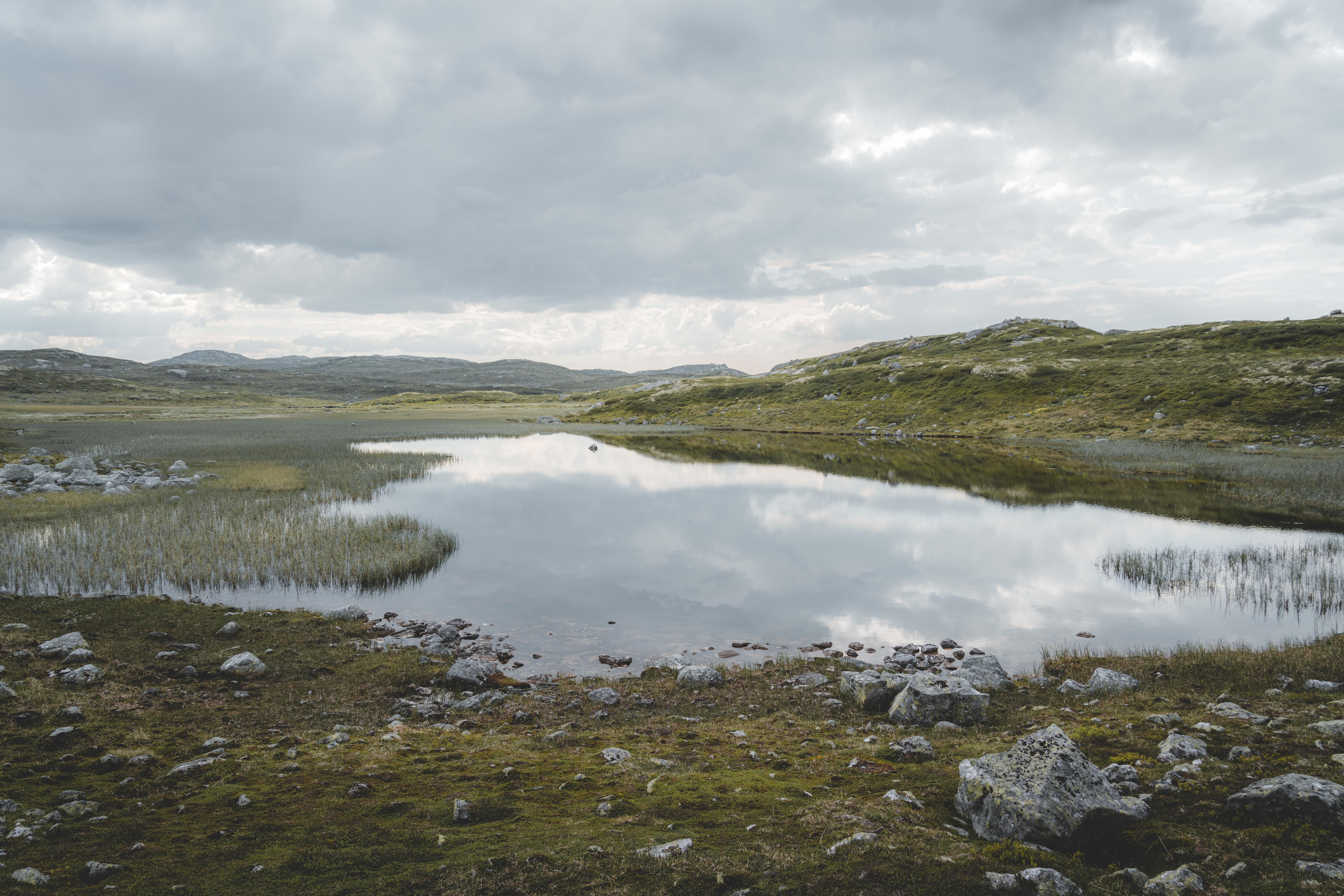 A mountain lake with clouds reflecting in the water.