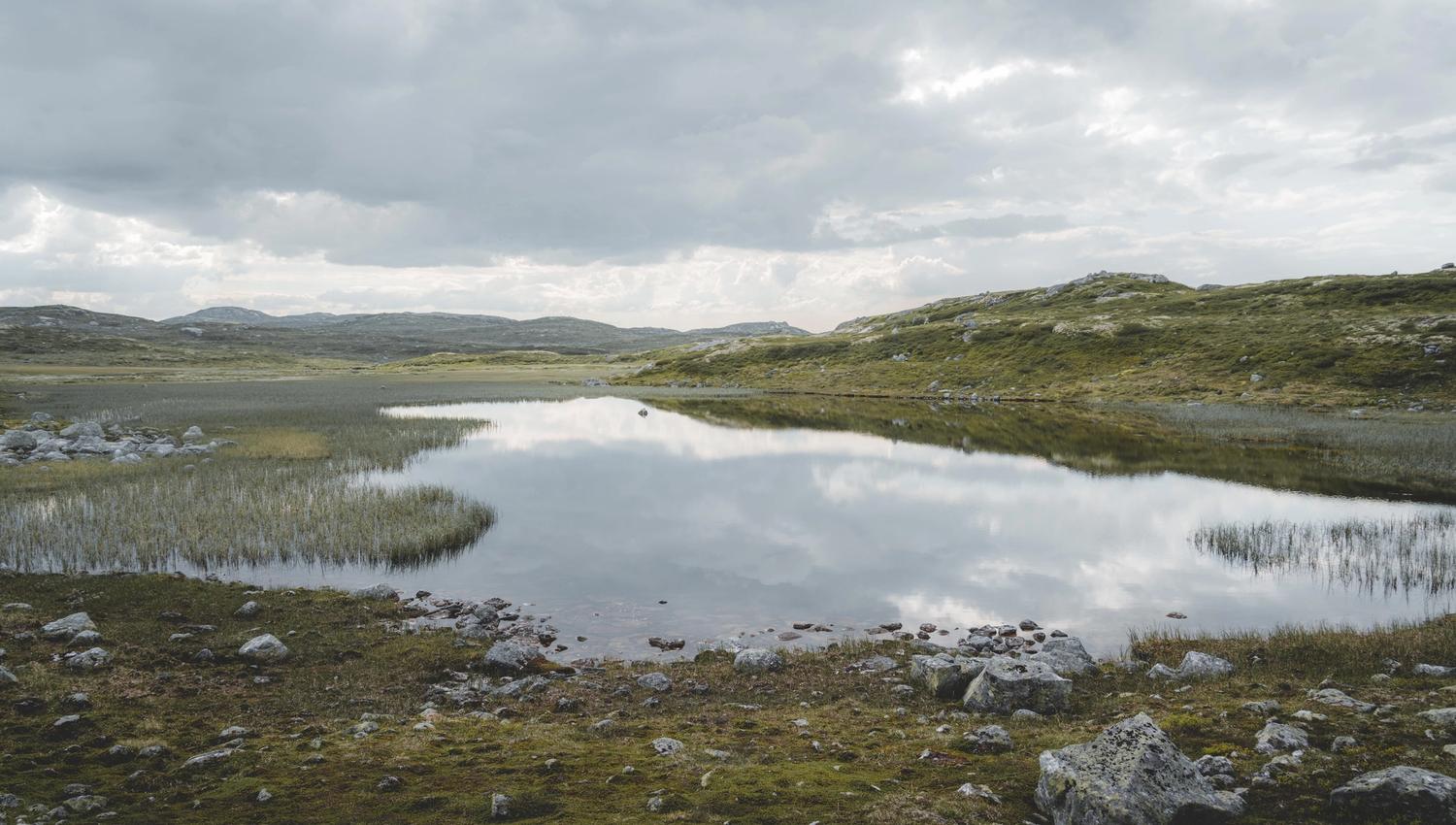 A mountain lake with clouds reflecting in the water.