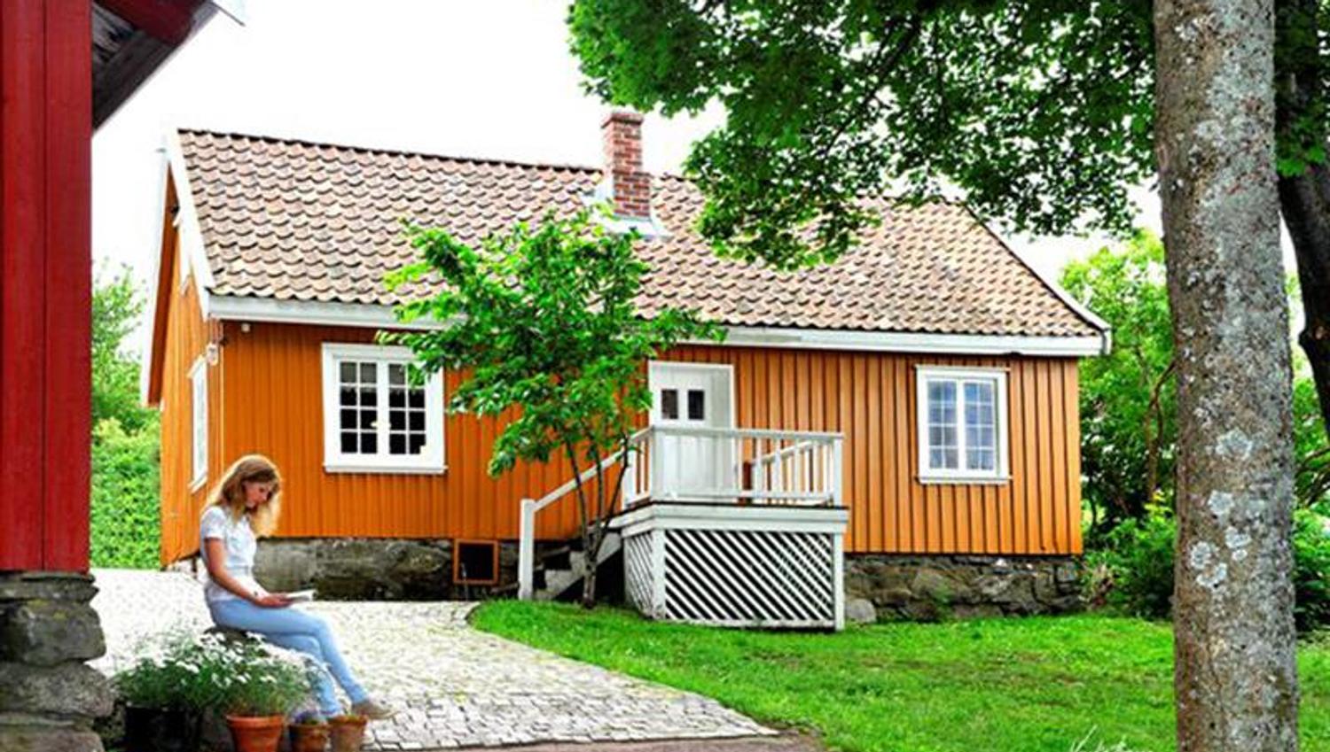 Munch's house seen from the driveway. A girl sitting outside of the house.