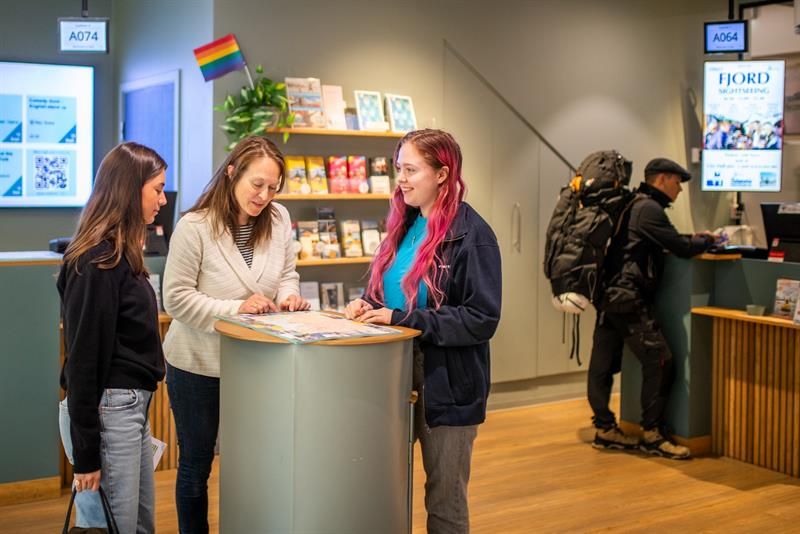 Employee assisting two customers at the tourist information office
