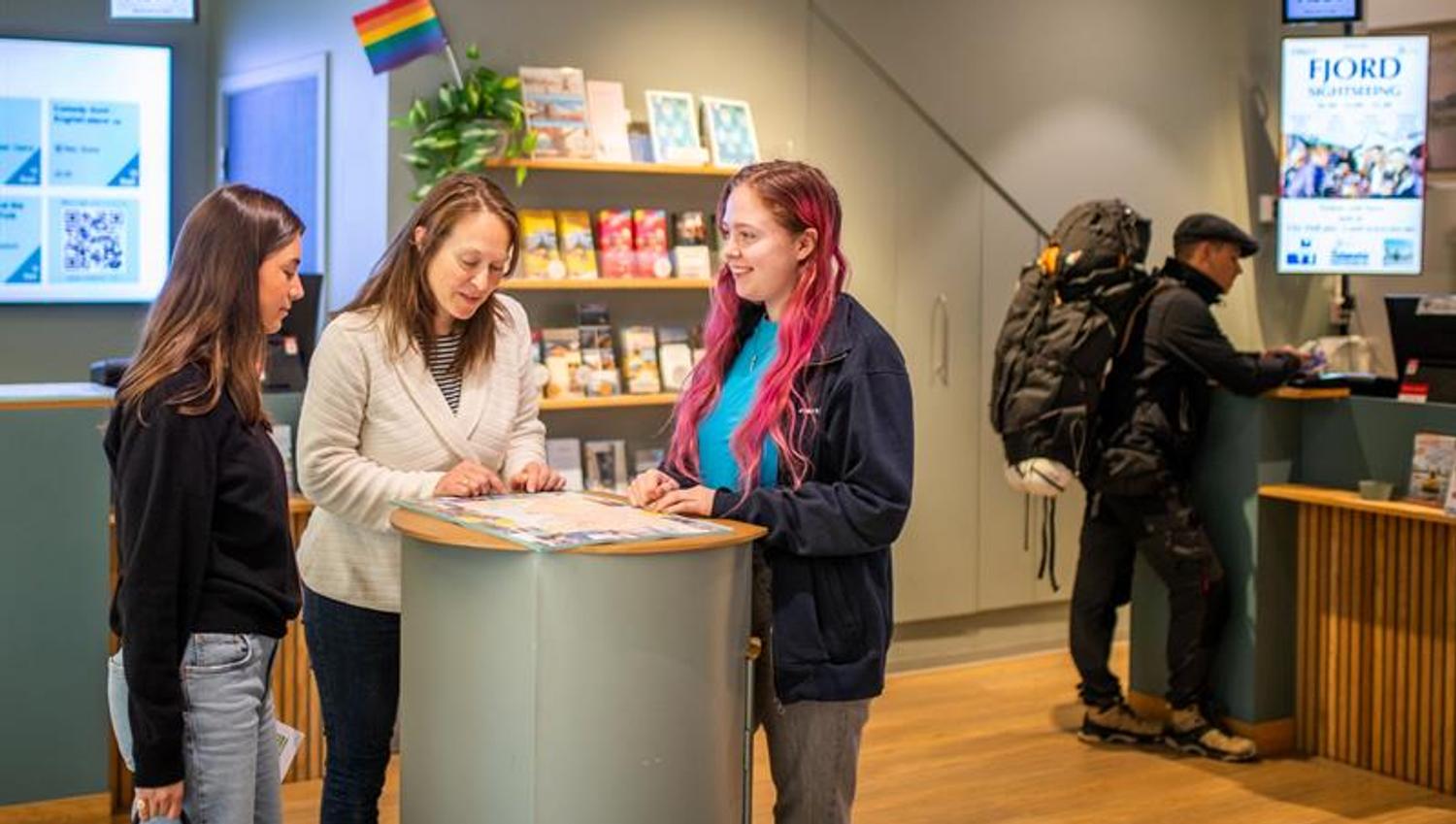 Employee assisting two customers at the tourist information office