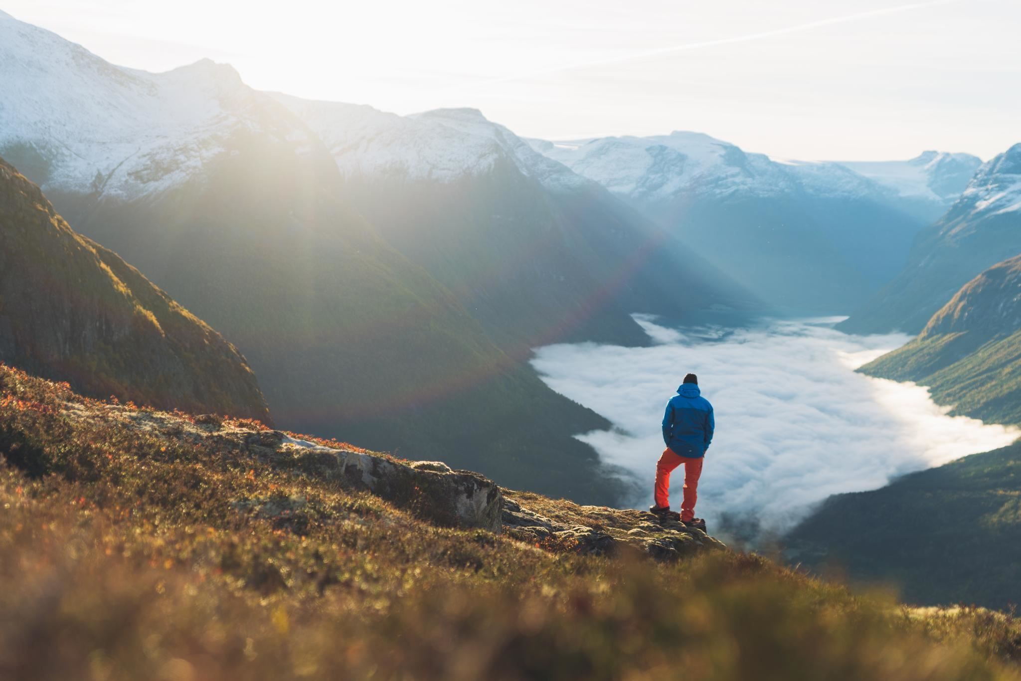 Hiker enjoying the mountain scenery and views over the fjord from Hoven.