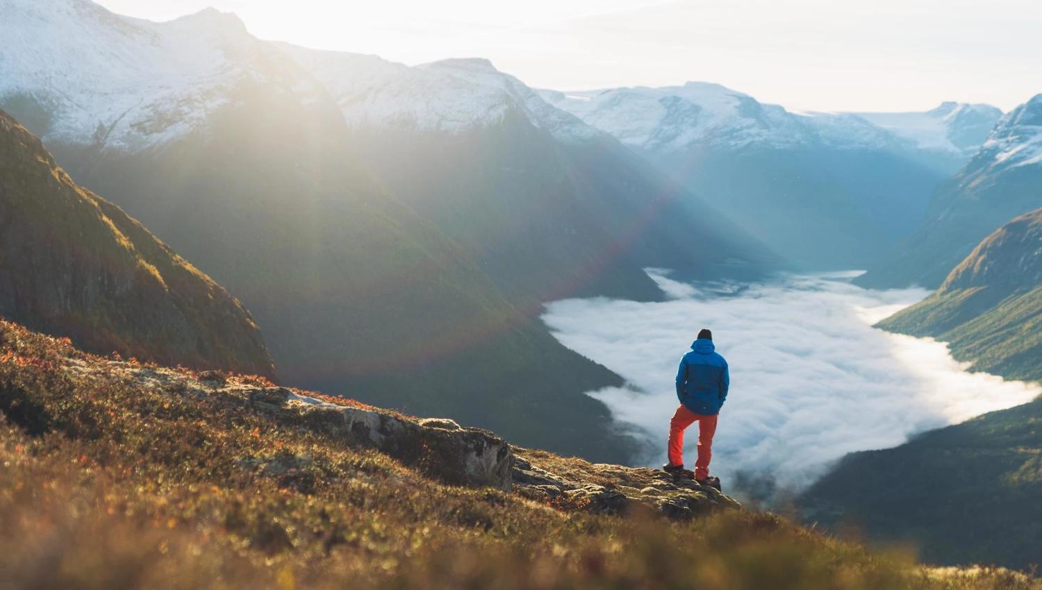Hiker enjoying the mountain scenery and views over the fjord from Hoven.