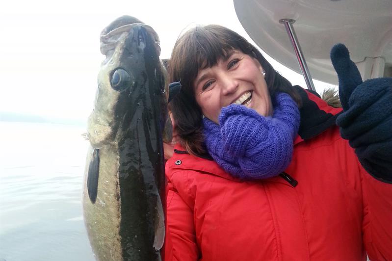 women in a boat with fish in her hand 