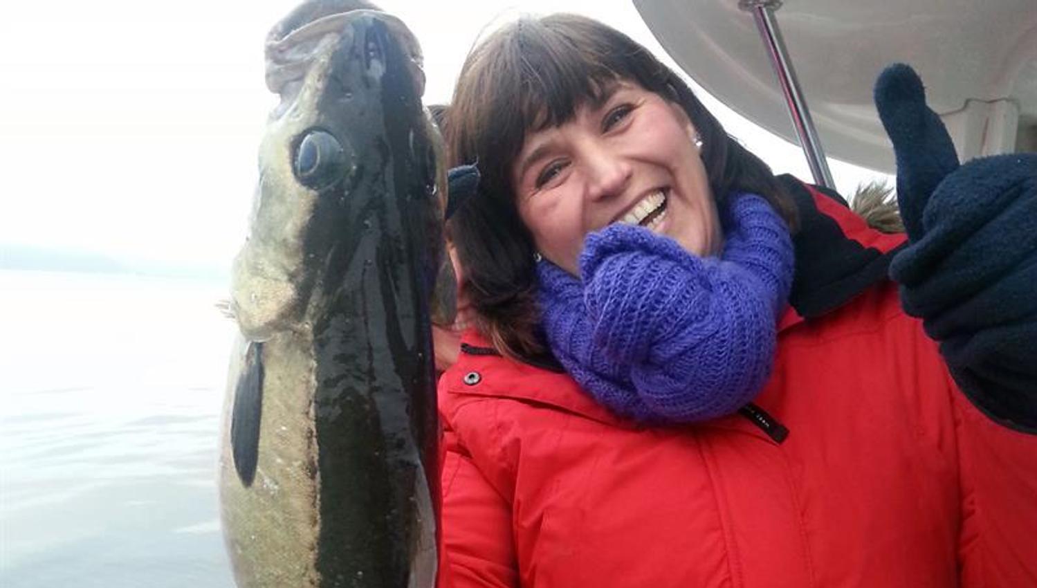 women in a boat with fish in her hand
