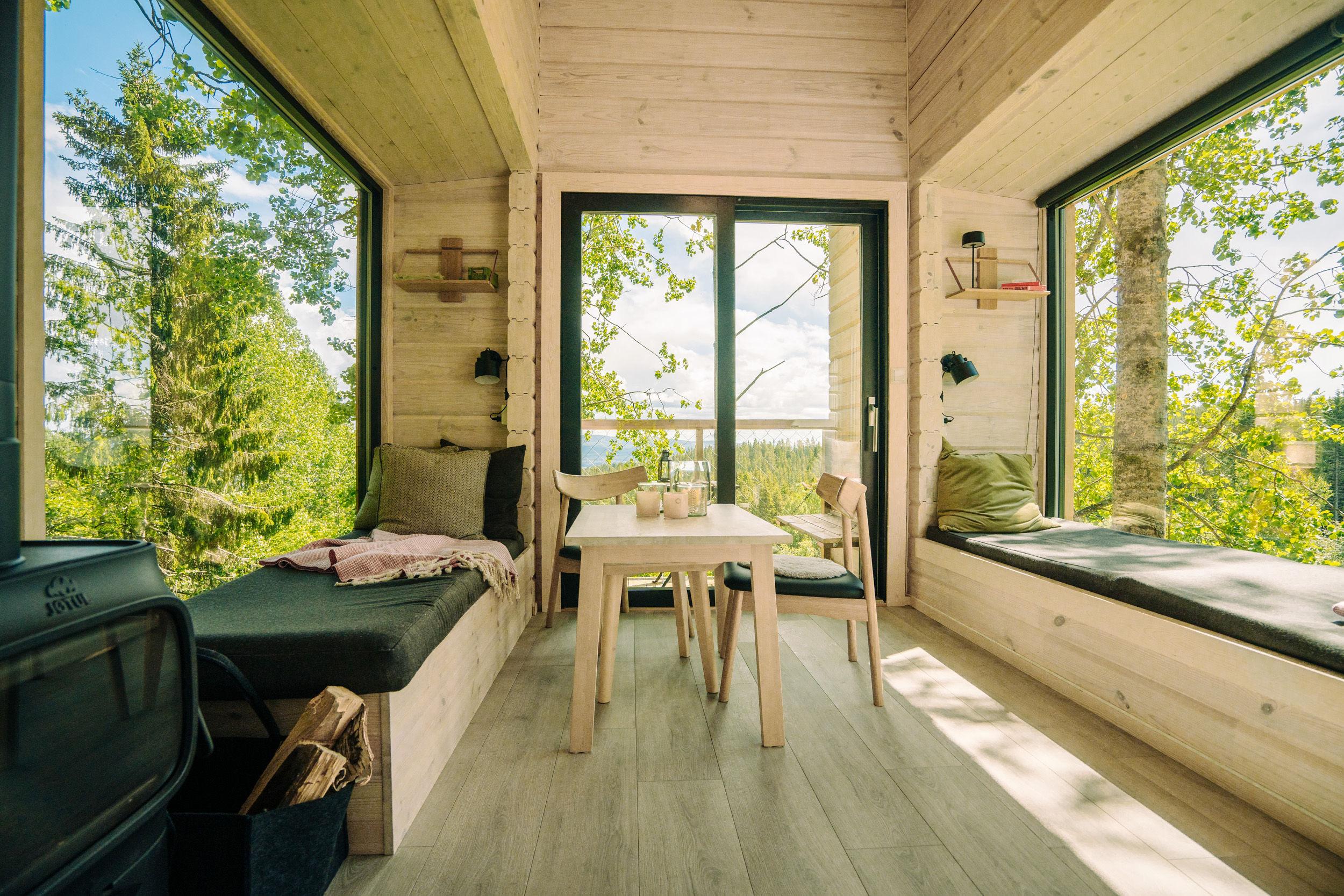 2 bed and a table in front of big windows