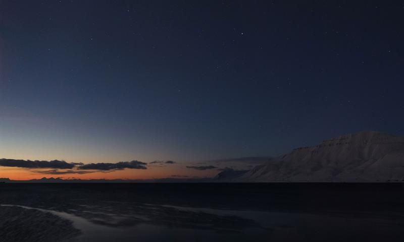 A beautiful sunset, with organs and blue light, and mountains to the right in the picture