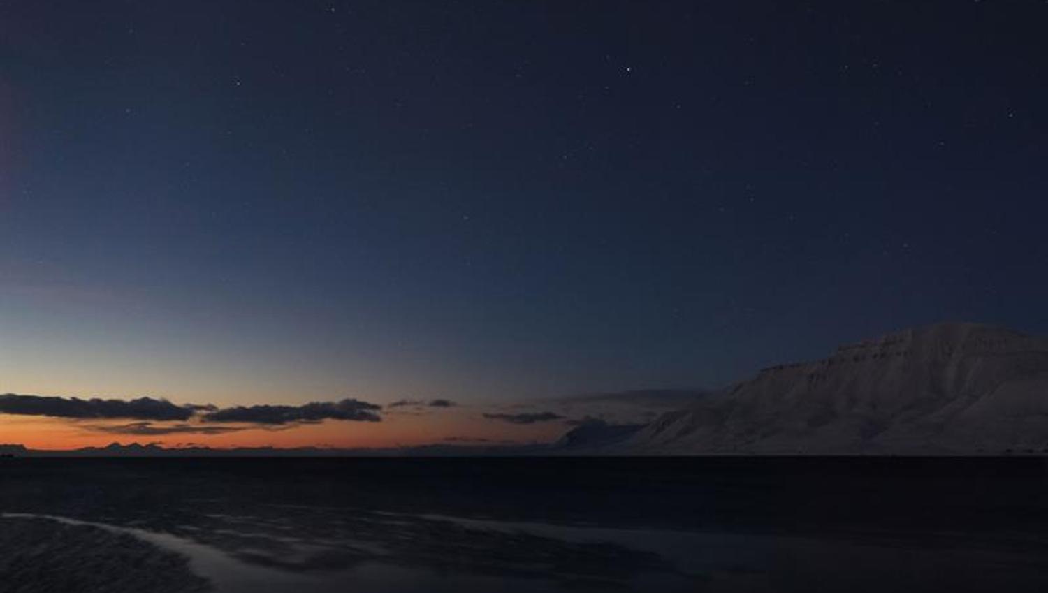 A beautiful sunset, with organs and blue light, and mountains to the right in the picture