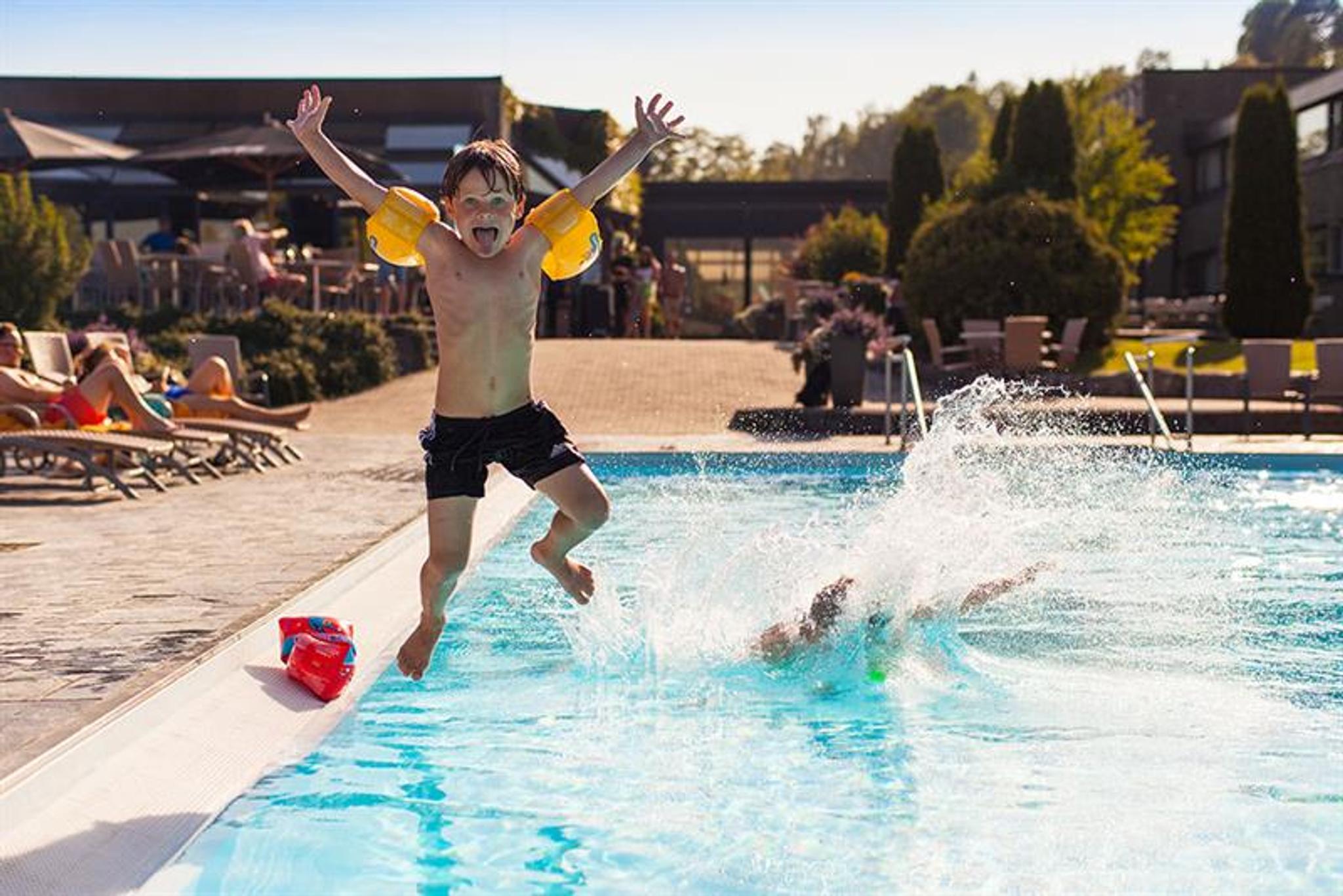 little boy jumps in swimming pool at Bø Hotel