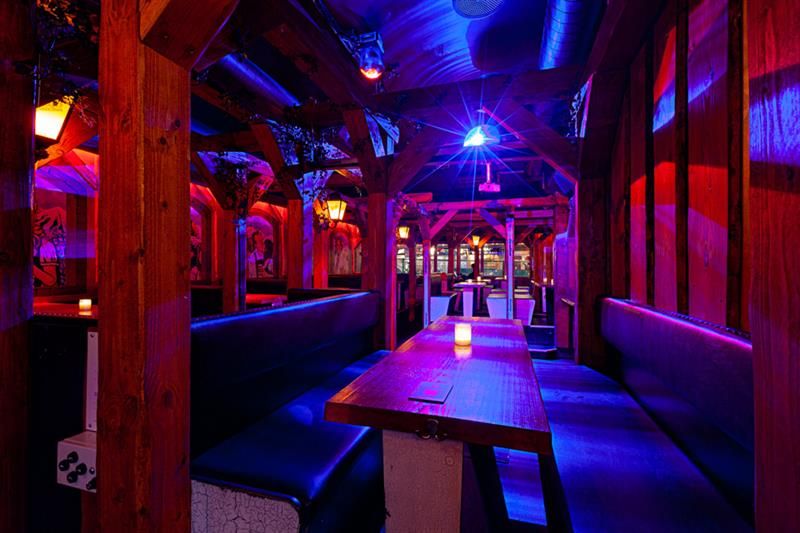 Bar interior with seating booths surrounded by neon lights