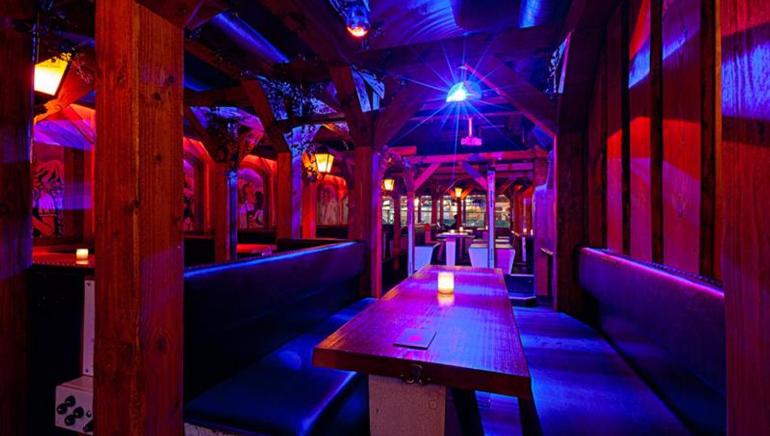 Bar interior with seating booths surrounded by neon lights