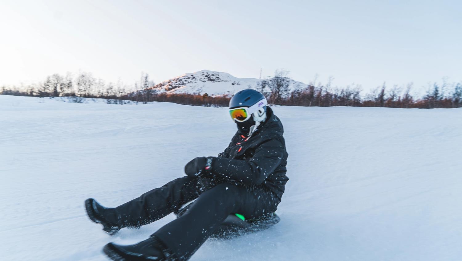 Person with helmet and goggles sledding down the alpine slope, photo