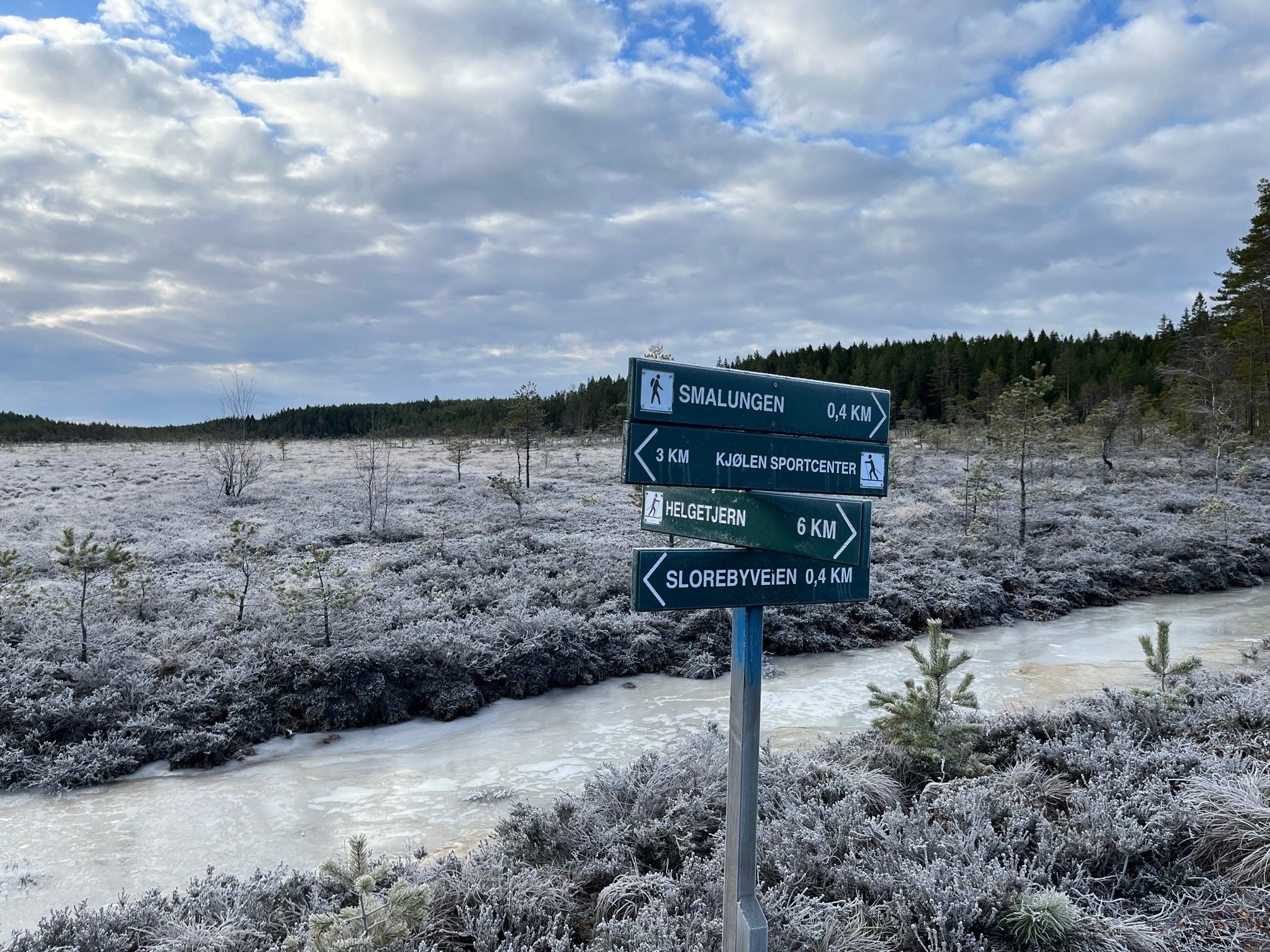 Utsikt over myrene. Skilt med forklaring hvor langt det er i ulike retningene.
