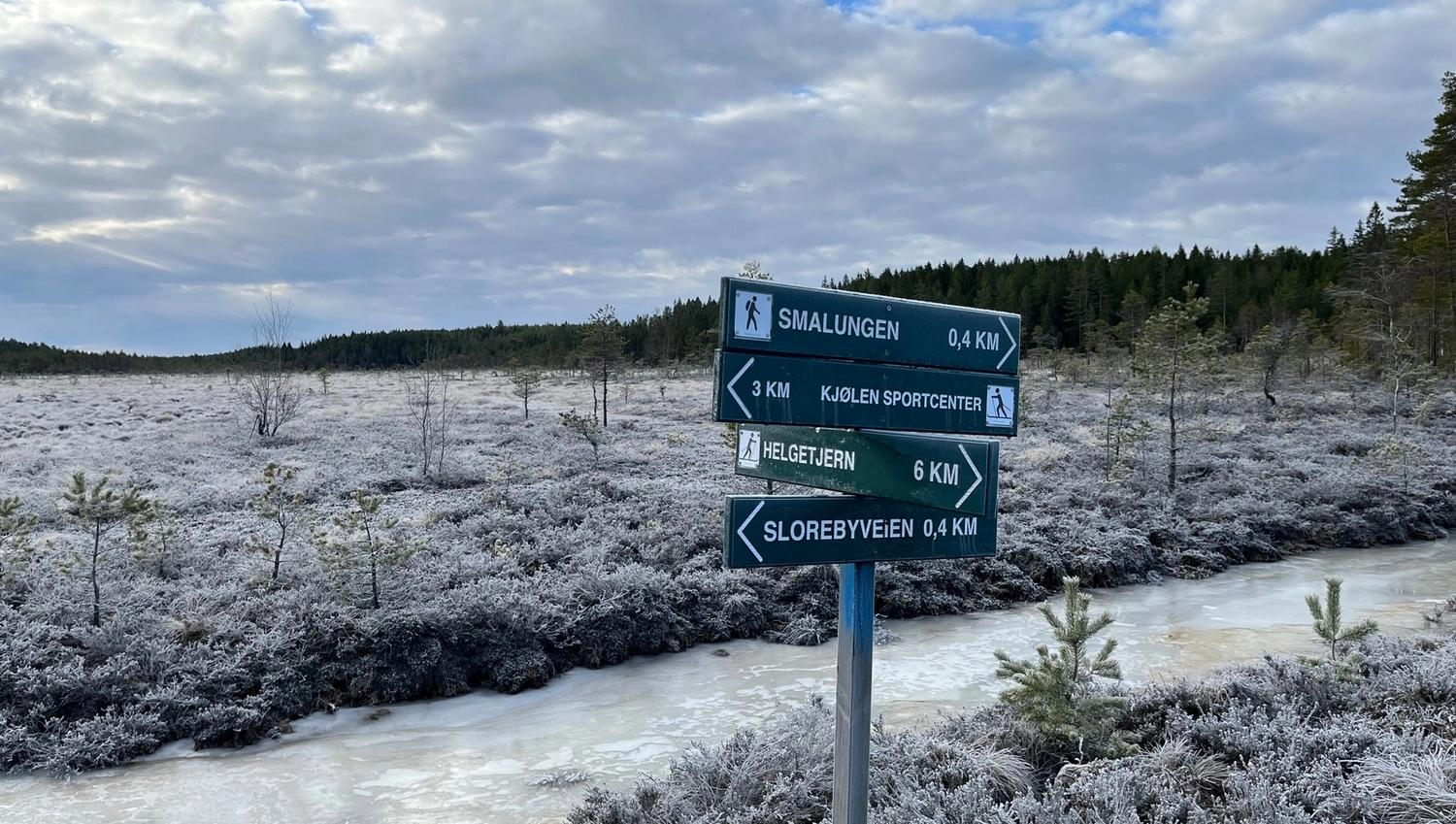 Utsikt over myrene. Skilt med forklaring hvor langt det er i ulike retningene.