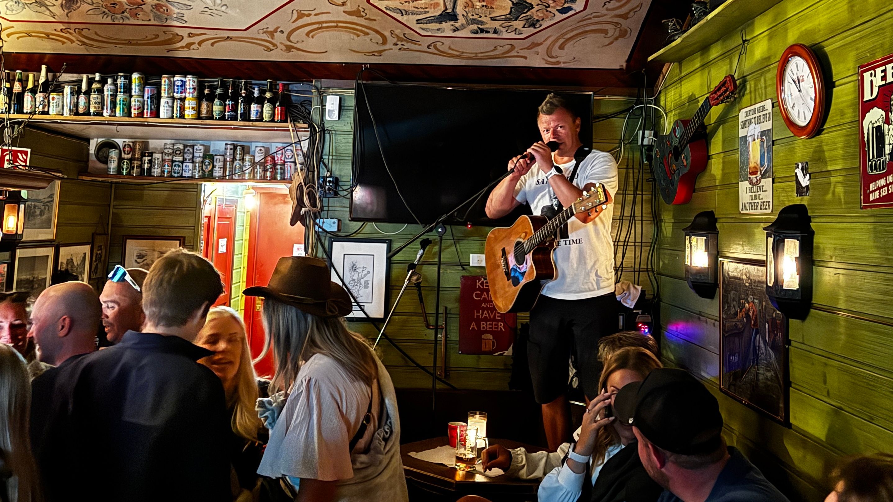Sanger med gitar underholder i en Pub