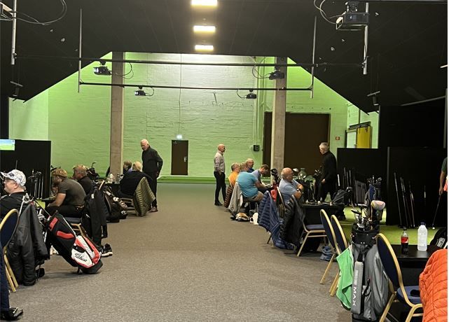 Sittende mennesker med golfsett