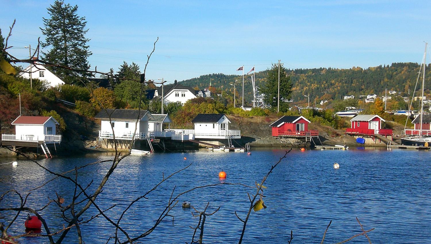 waterfront bathhouse, blue sky and fjord