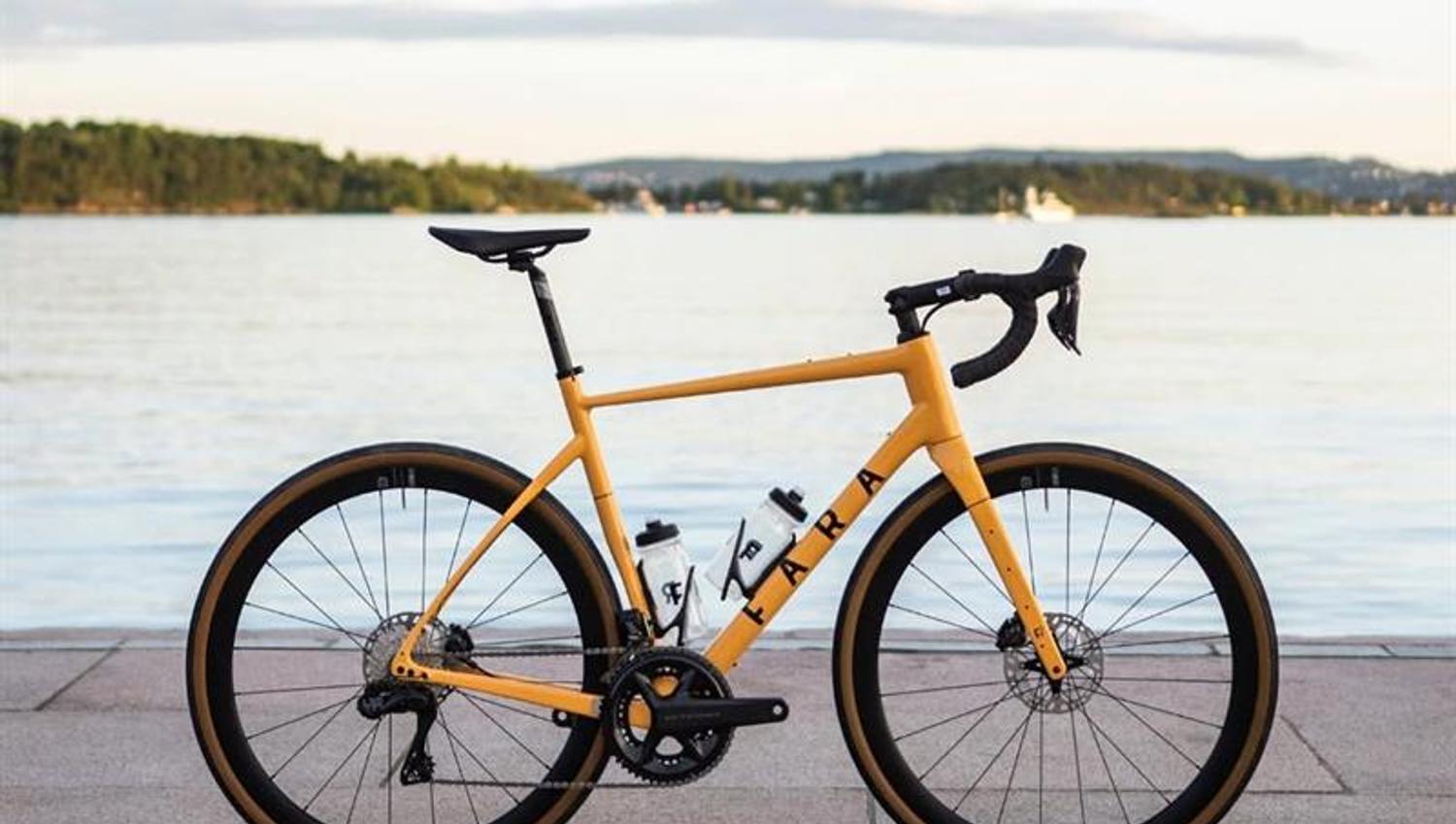A yellow bicycle set up with the Oslofjord in the background