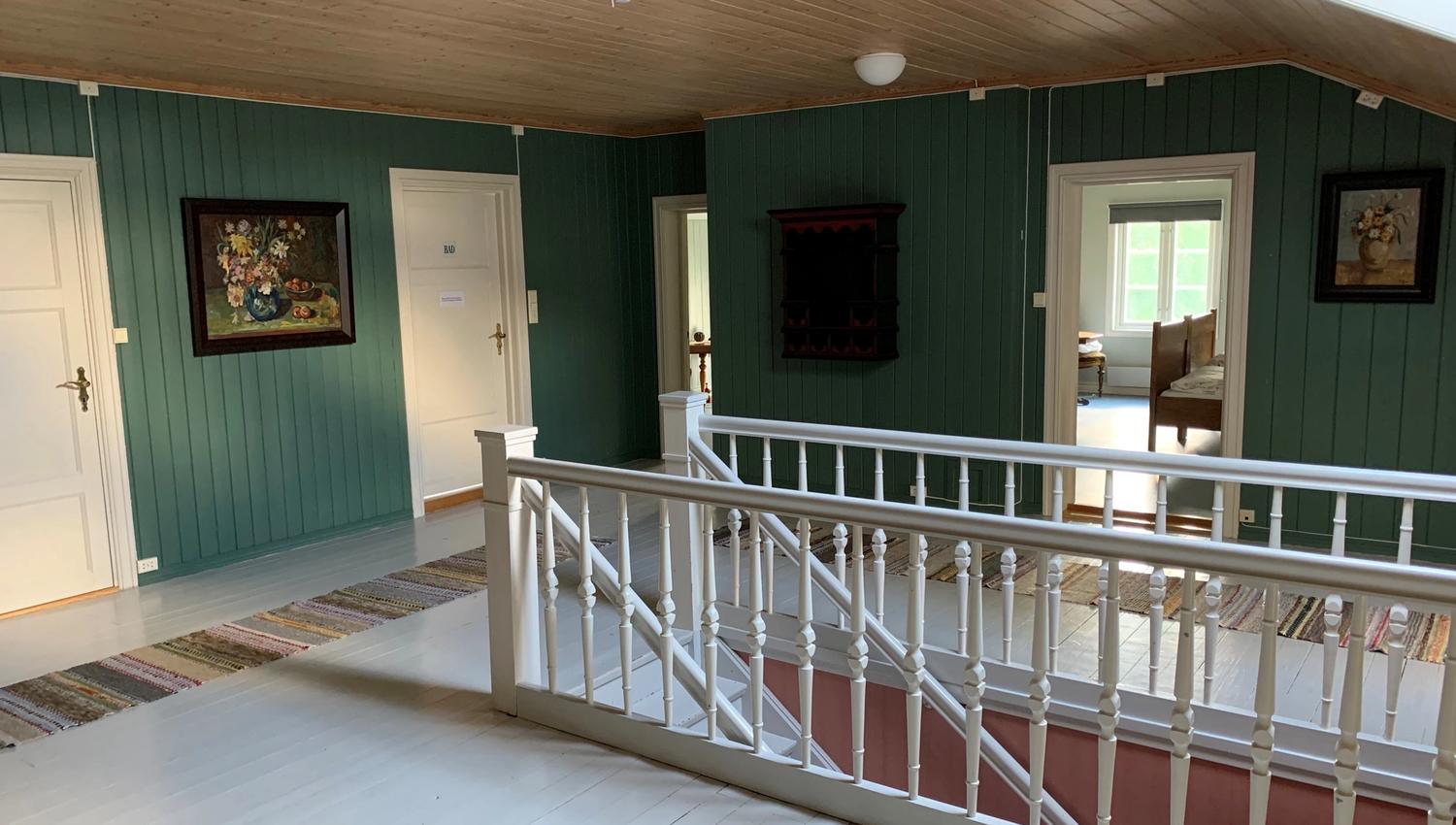Rom med grønne vegger og en trapp som går ned.