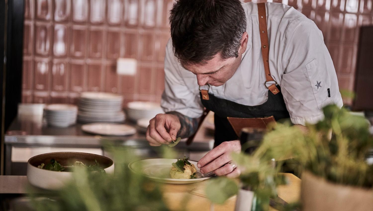Chef prepares food in the kitchen at Hotell Klubben
