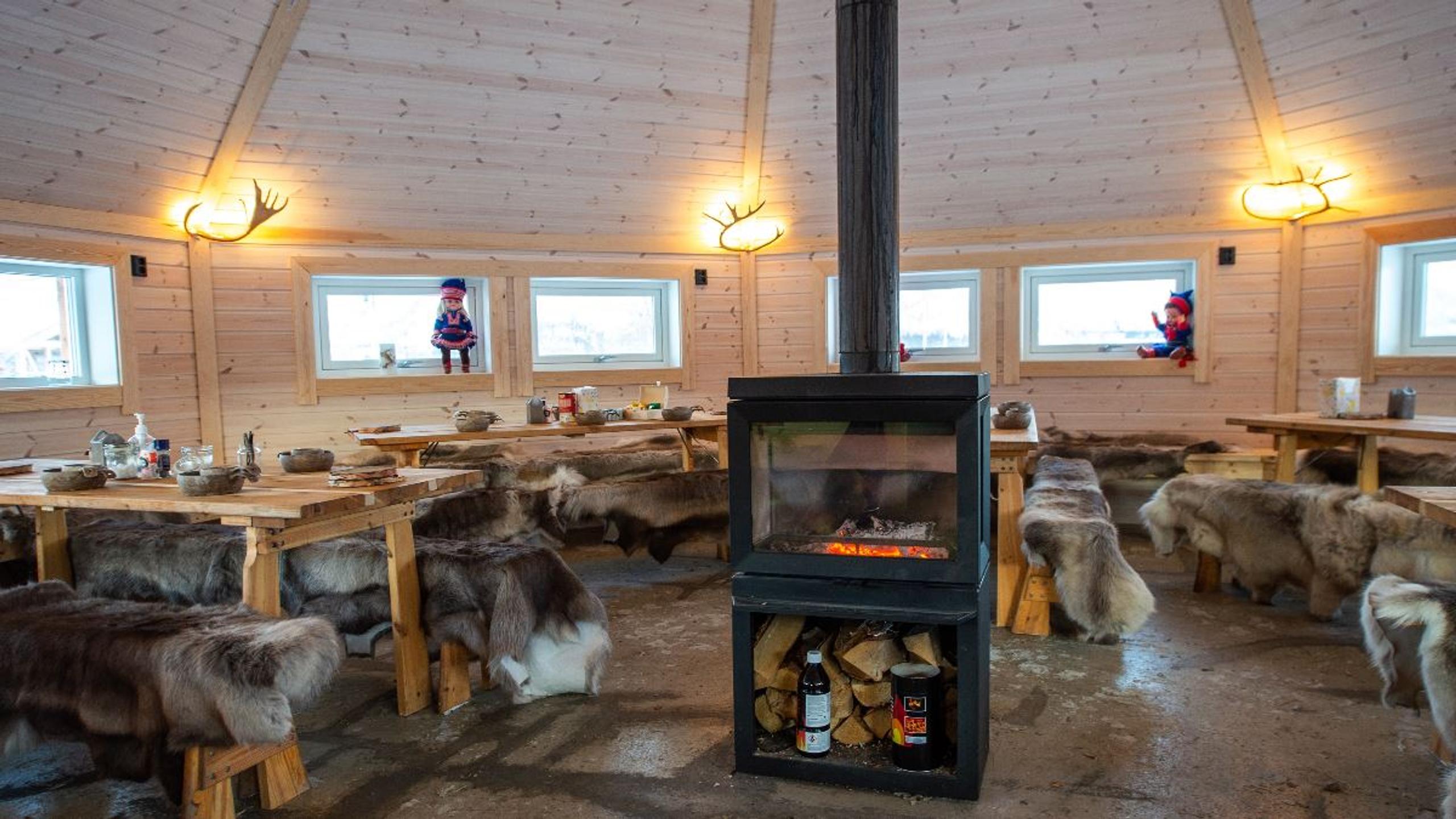 Traditional Sámi lavvu with a fireplace and seating at Tromsø Lapland’s reindeer camp near Tromsø.