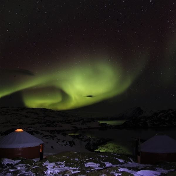 Northern lights over small huts