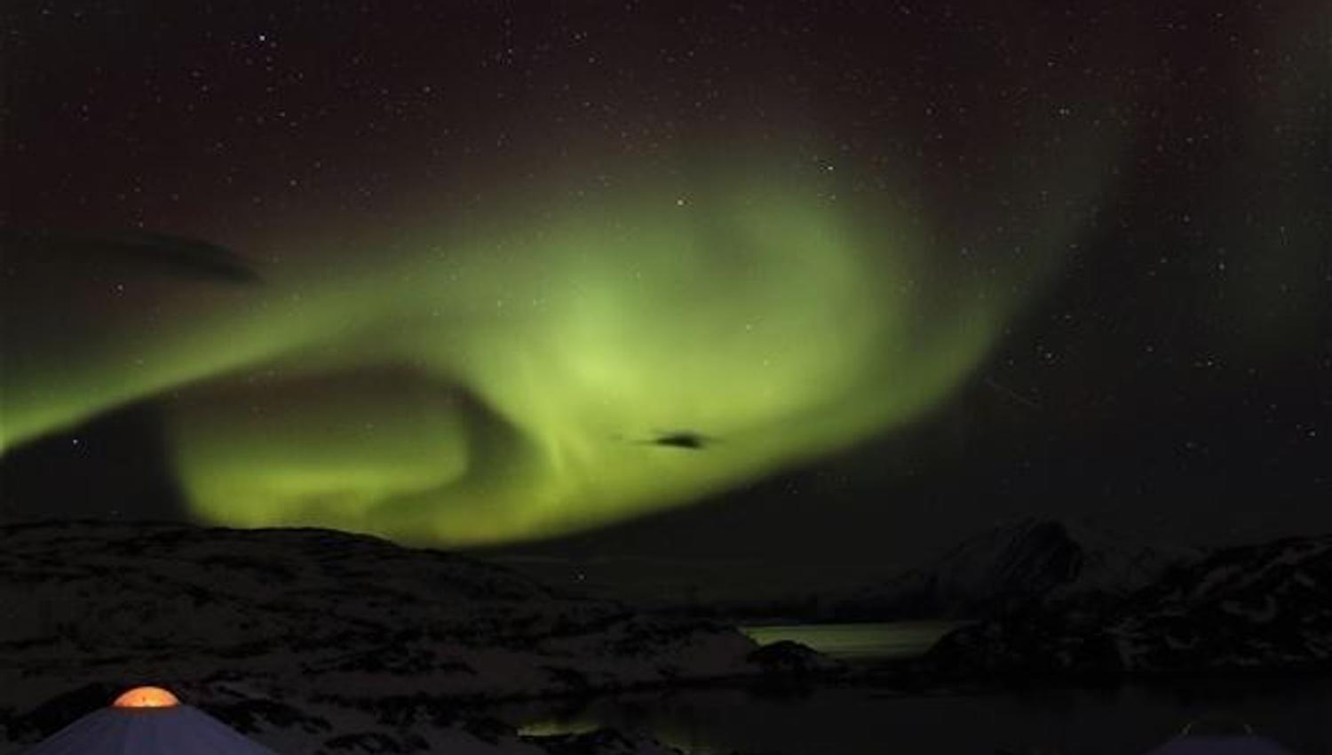 Northern lights over small huts