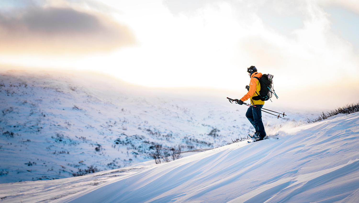 Solo trekker on snowshoes across snowy hills in Hardanger.