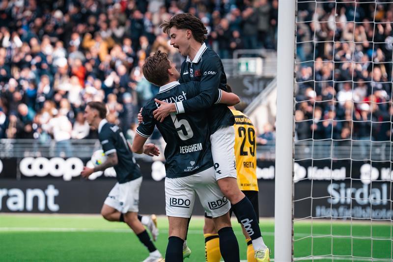 To fotballspillere i Viking FK feirer et mål foran fullsatte tribuner