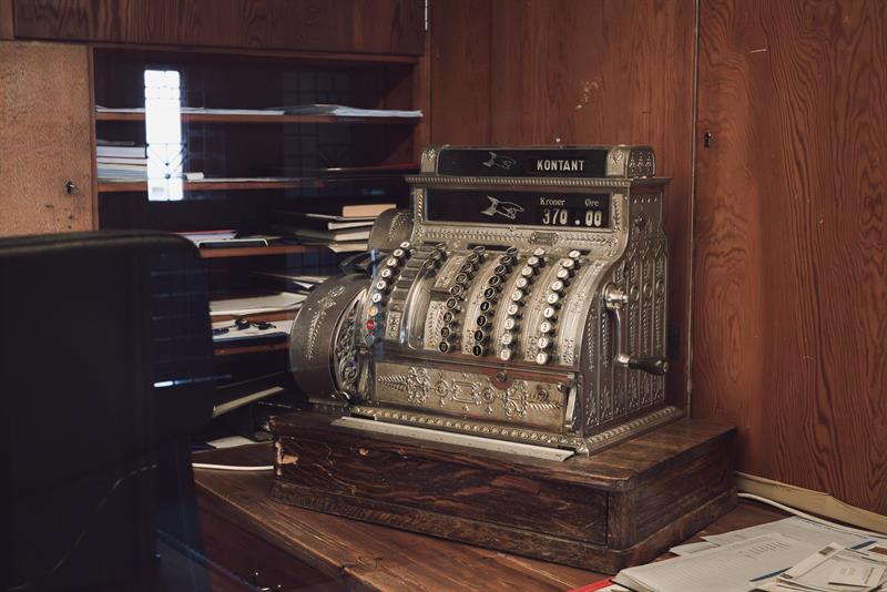 An old silver cash register with the word “Cash” displayed on the screen.