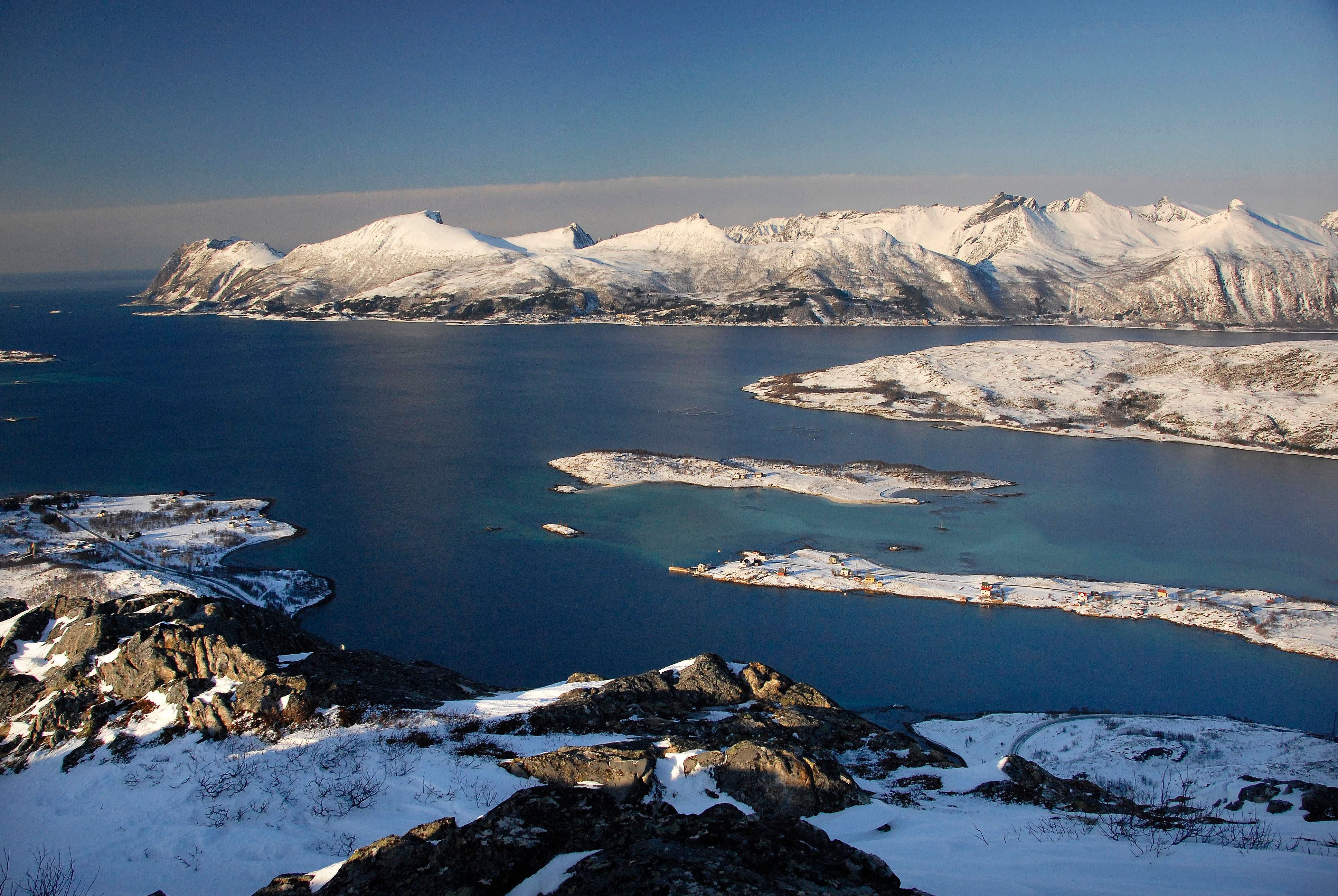 Snødekte fjell og øyer langs kysten av Senja om vinteren