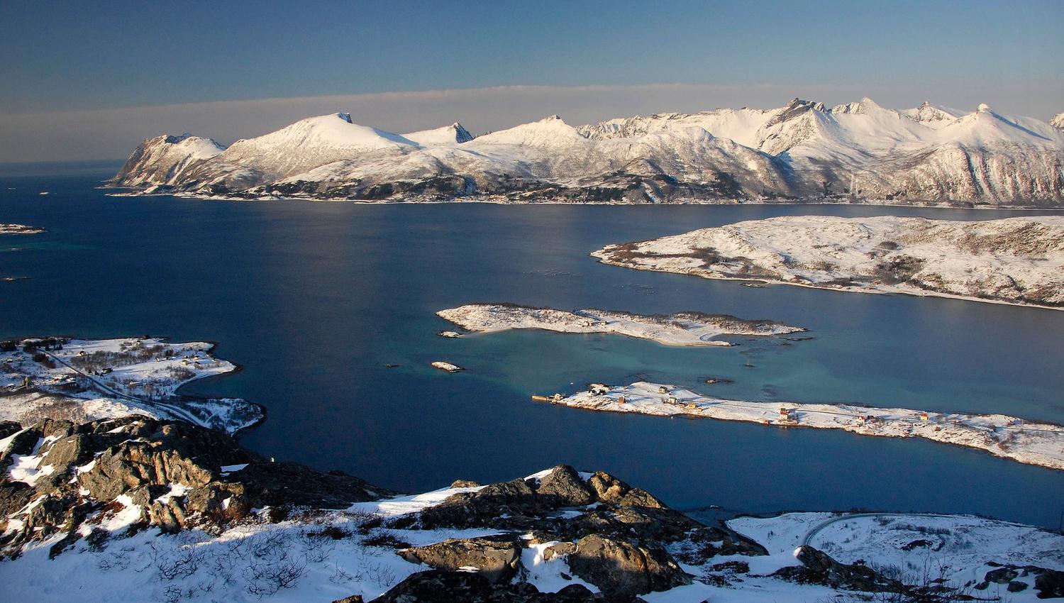 Snødekte fjell og øyer langs kysten av Senja om vinteren