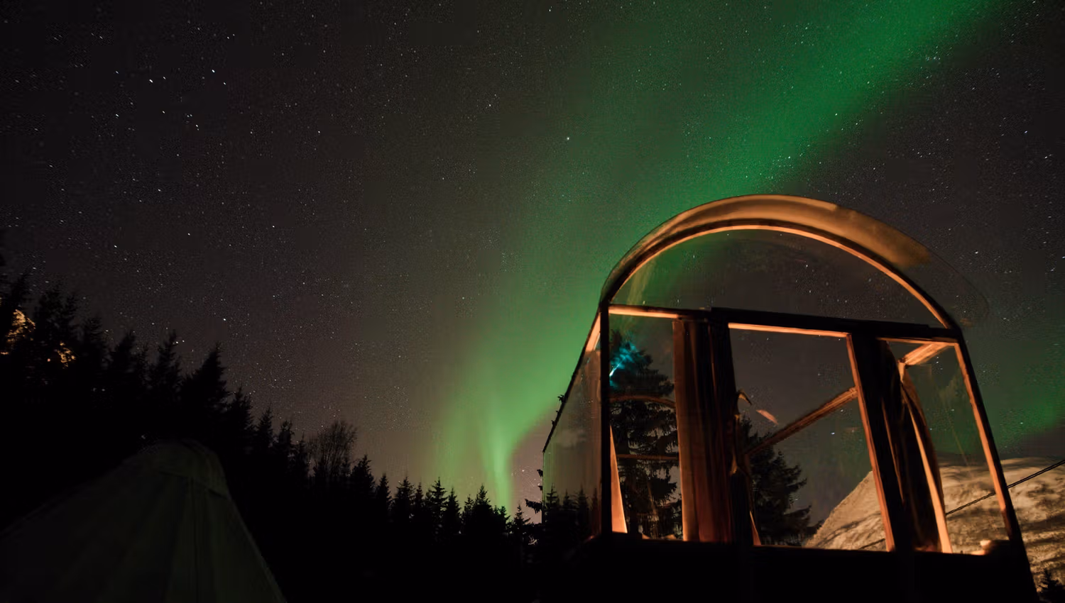 glasshytta med nordlys over