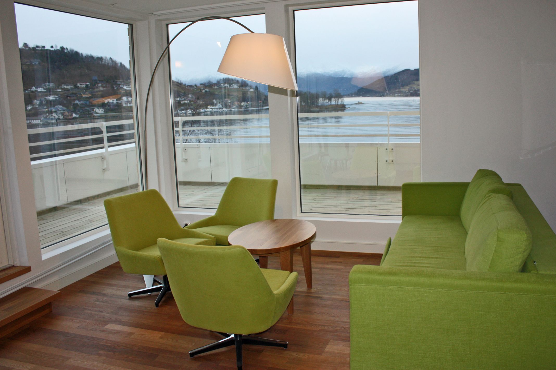 Modern lounge at Thon Hotel Sandven with stylish green furniture and a stunning view of the Hardangerfjord.
