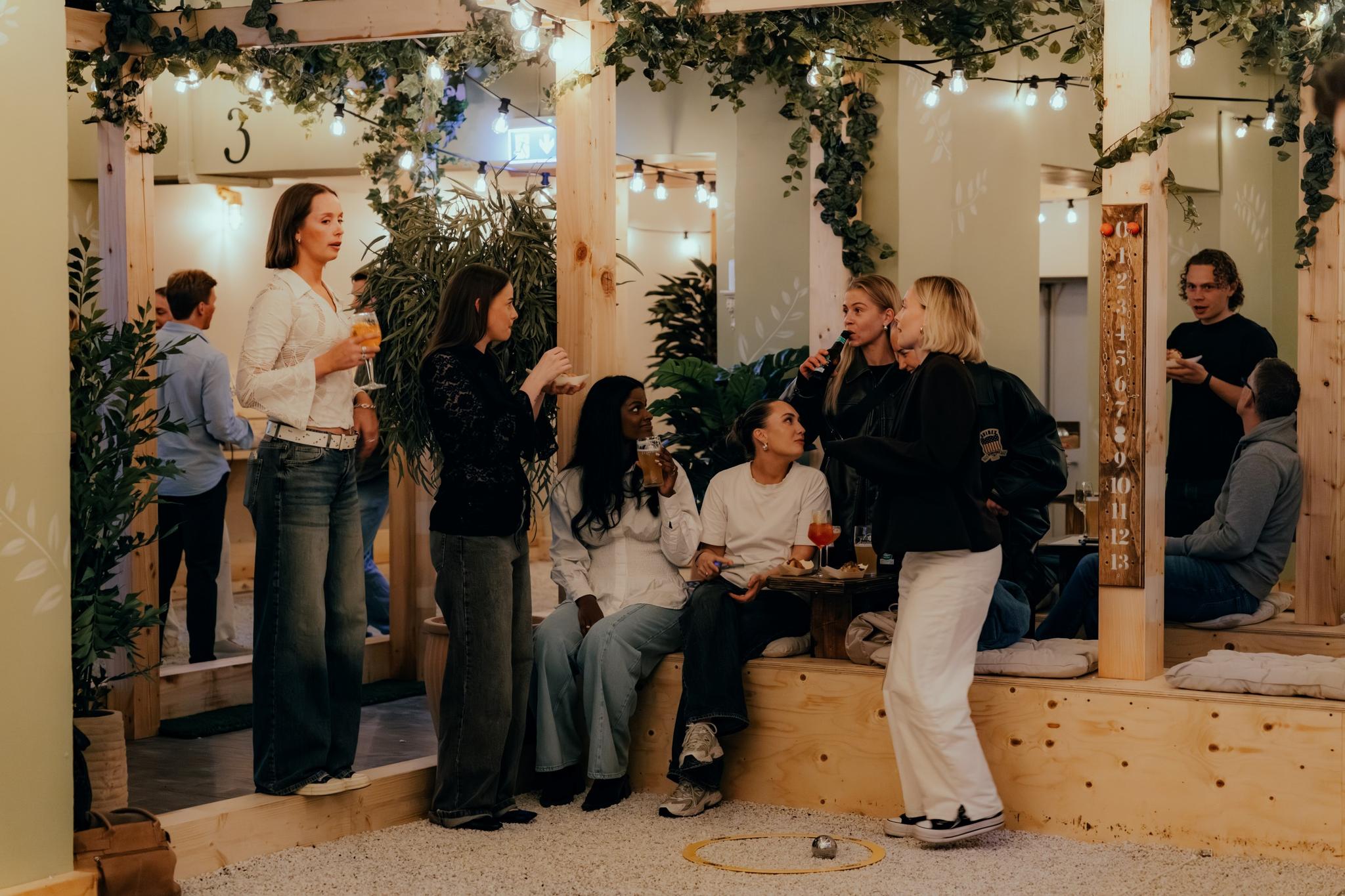 A gang of girls drinking wine and playing boule