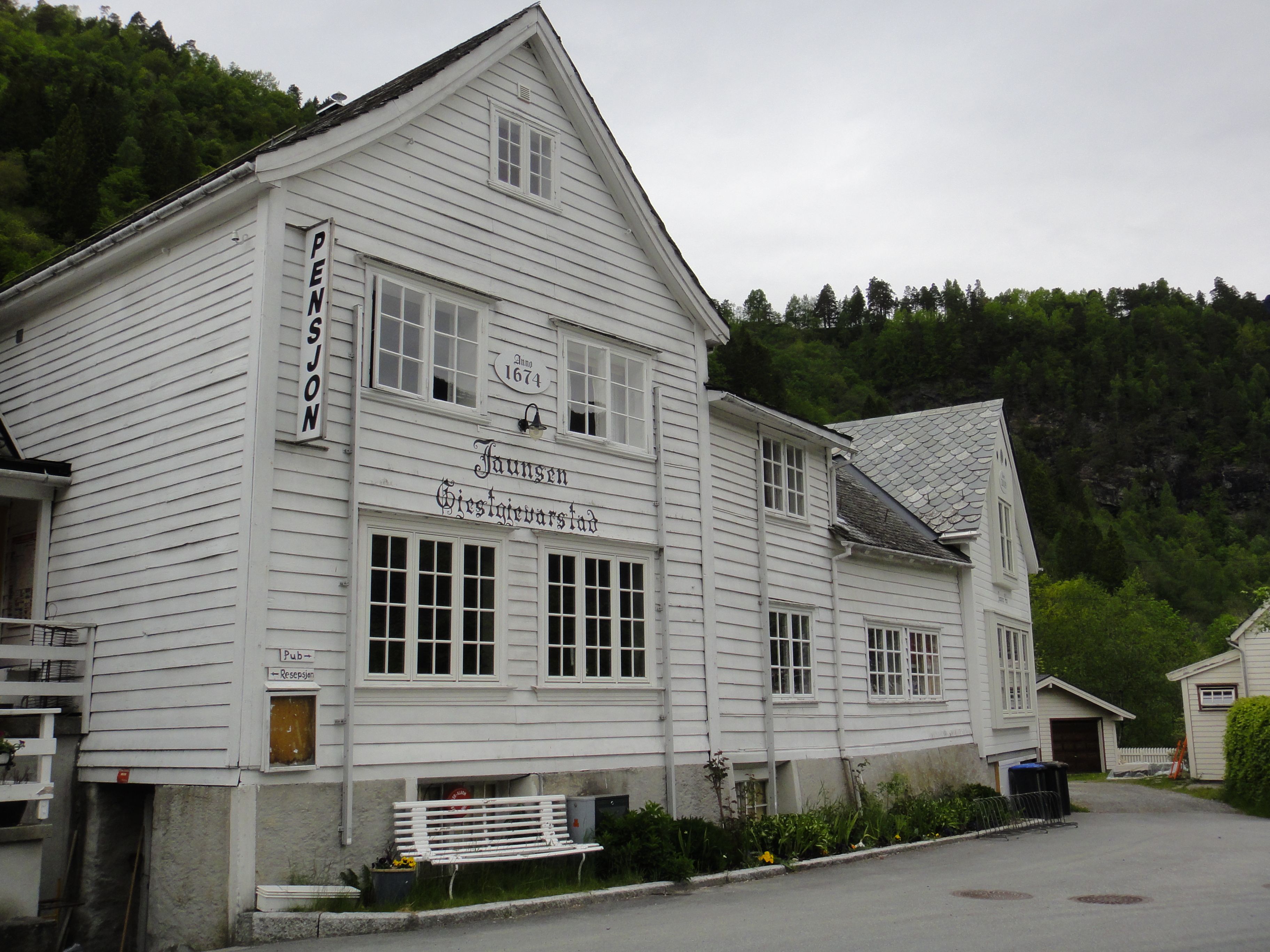 The historic exterior of Jaunsen Guesthouse from 1674, surrounded by beautiful Hardanger nature.