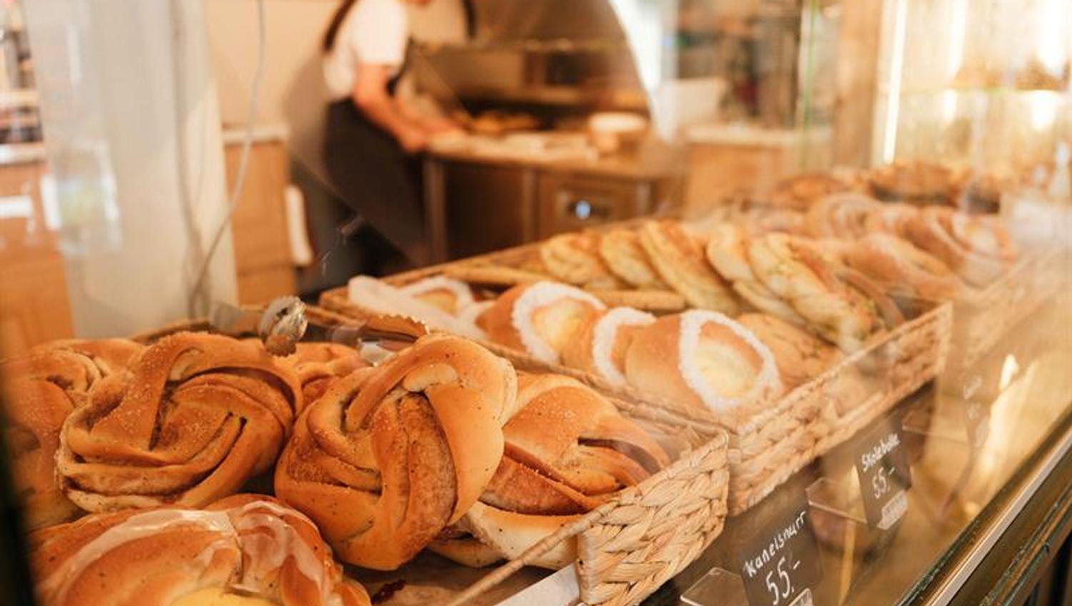 Yeast pastries and cinnamon buns are temptingly displayed in the counter at Iversen Bakery and Gallery, with the bakery and a staff member working in