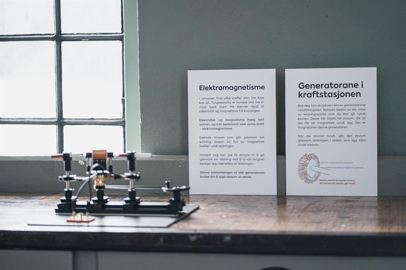 Information board on electromagnetism and generators at the Kraftmuseet, featuring a small display model.