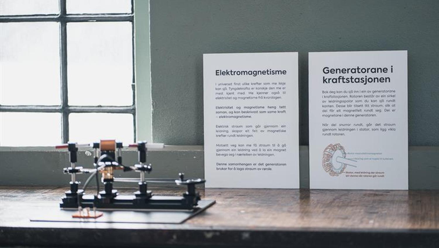 Information board on electromagnetism and generators at the Kraftmuseet, featuring a small display model.
