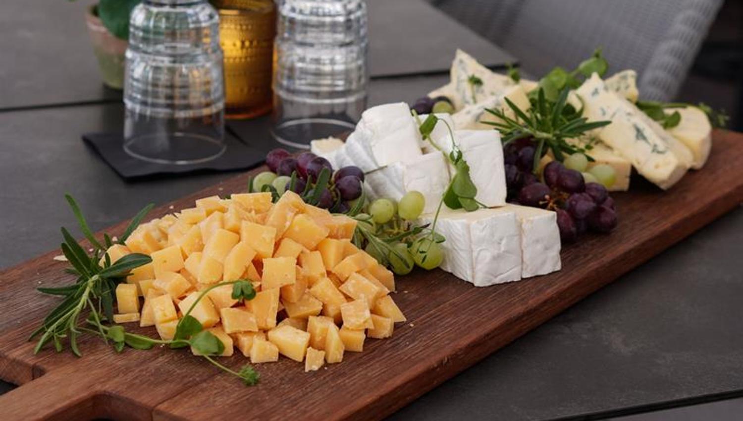 Detail of cheese board and grapes on a table.
