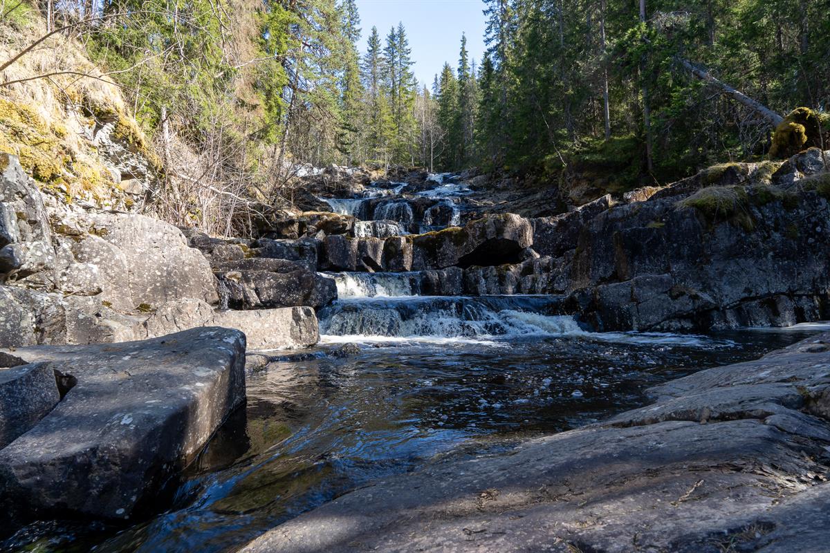 Small waterfall and stream in rocky terrain.