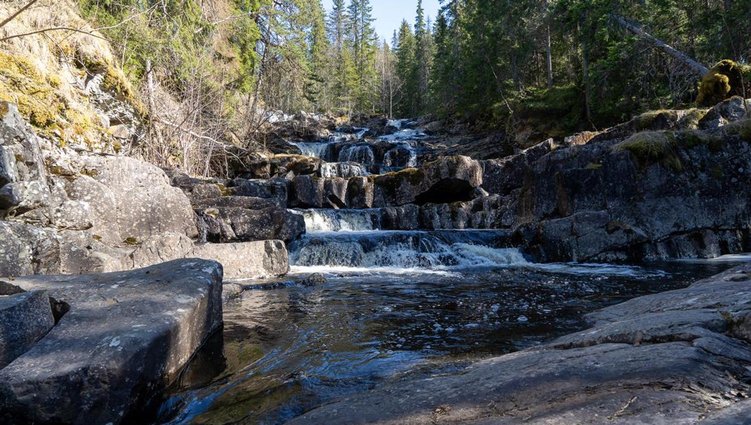Small waterfall and stream in rocky terrain.