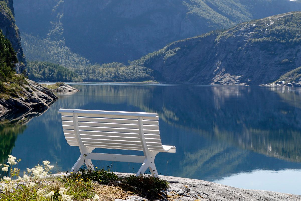 Hvit benk ved vannet ved Flatanger Camping