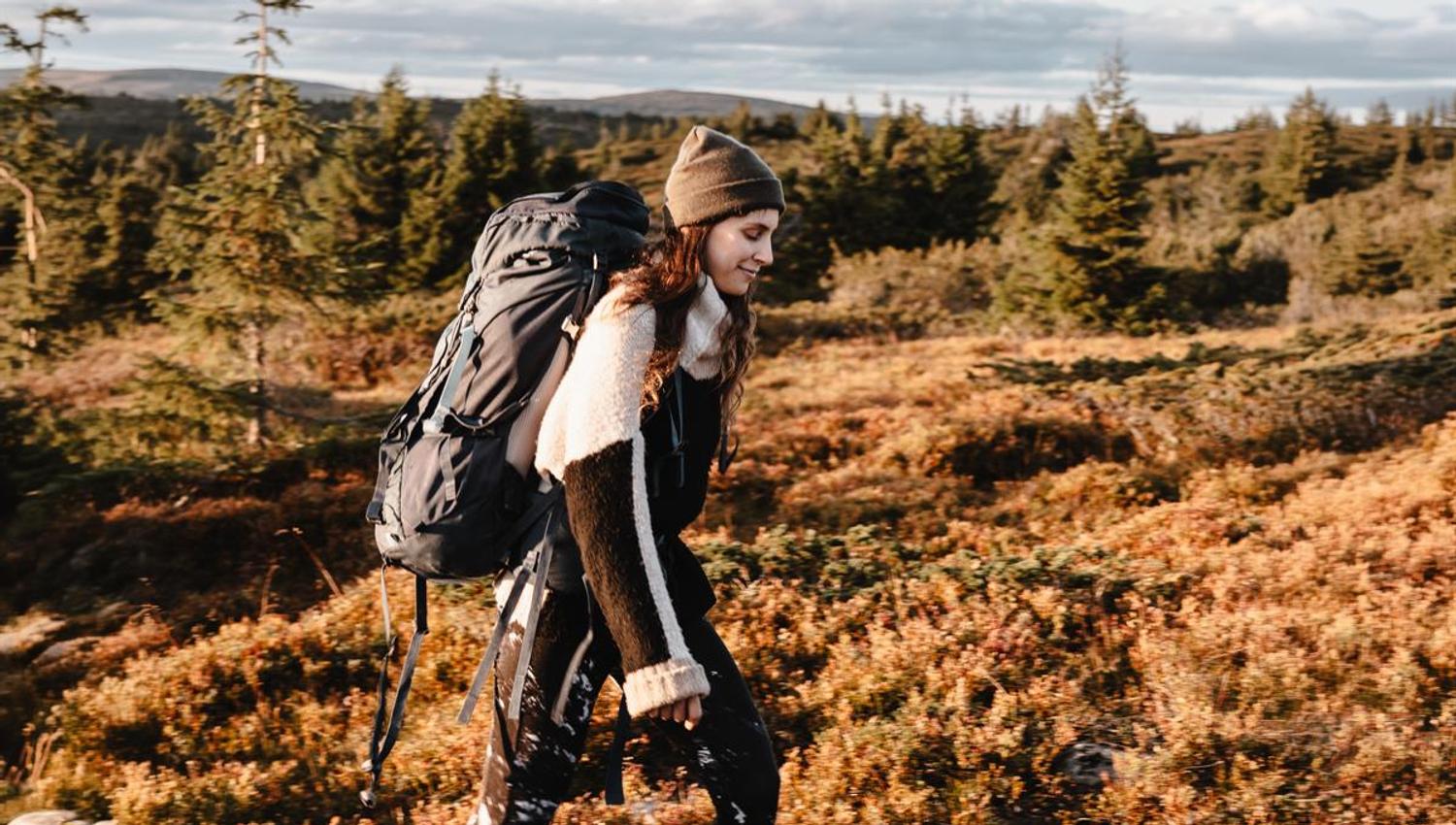 Person with backpack hiking in rugged mountain terrain