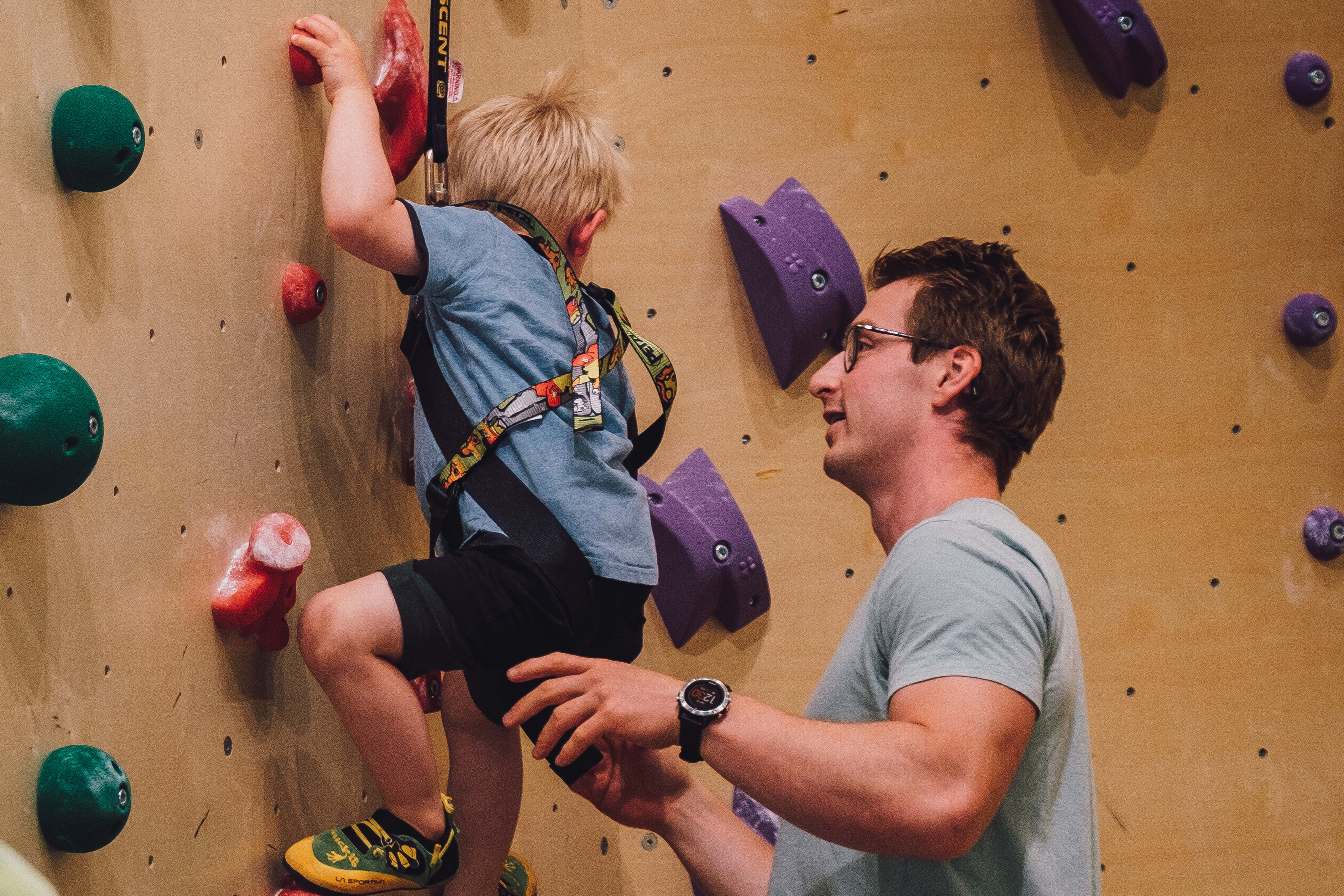 Boy climbing, father assisting