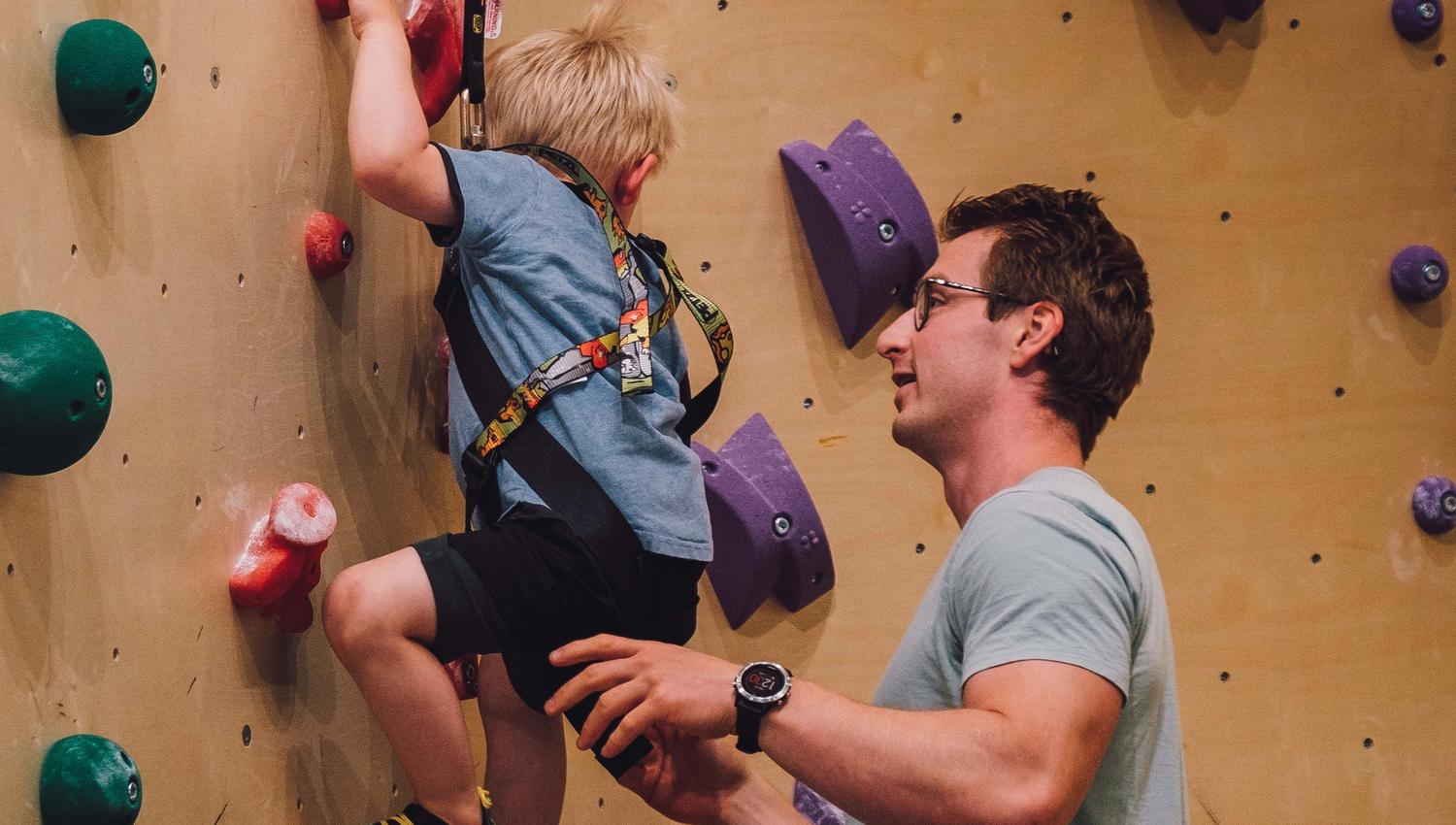 Boy climbing, father assisting